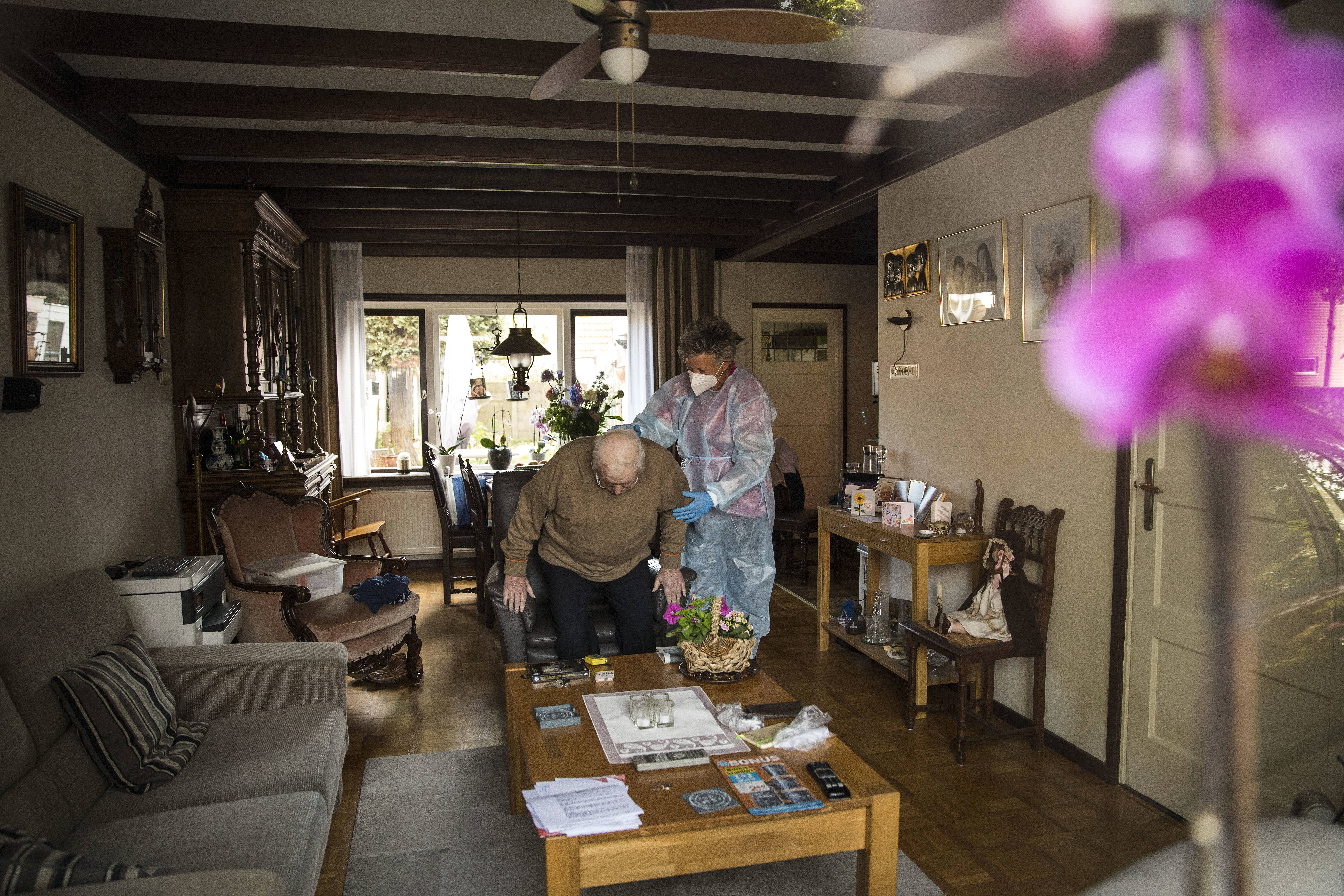 Coronavirus: Wijkverpleegkundige met mondkapje en beschermingsmiddelen (Arie Kievit ANP)