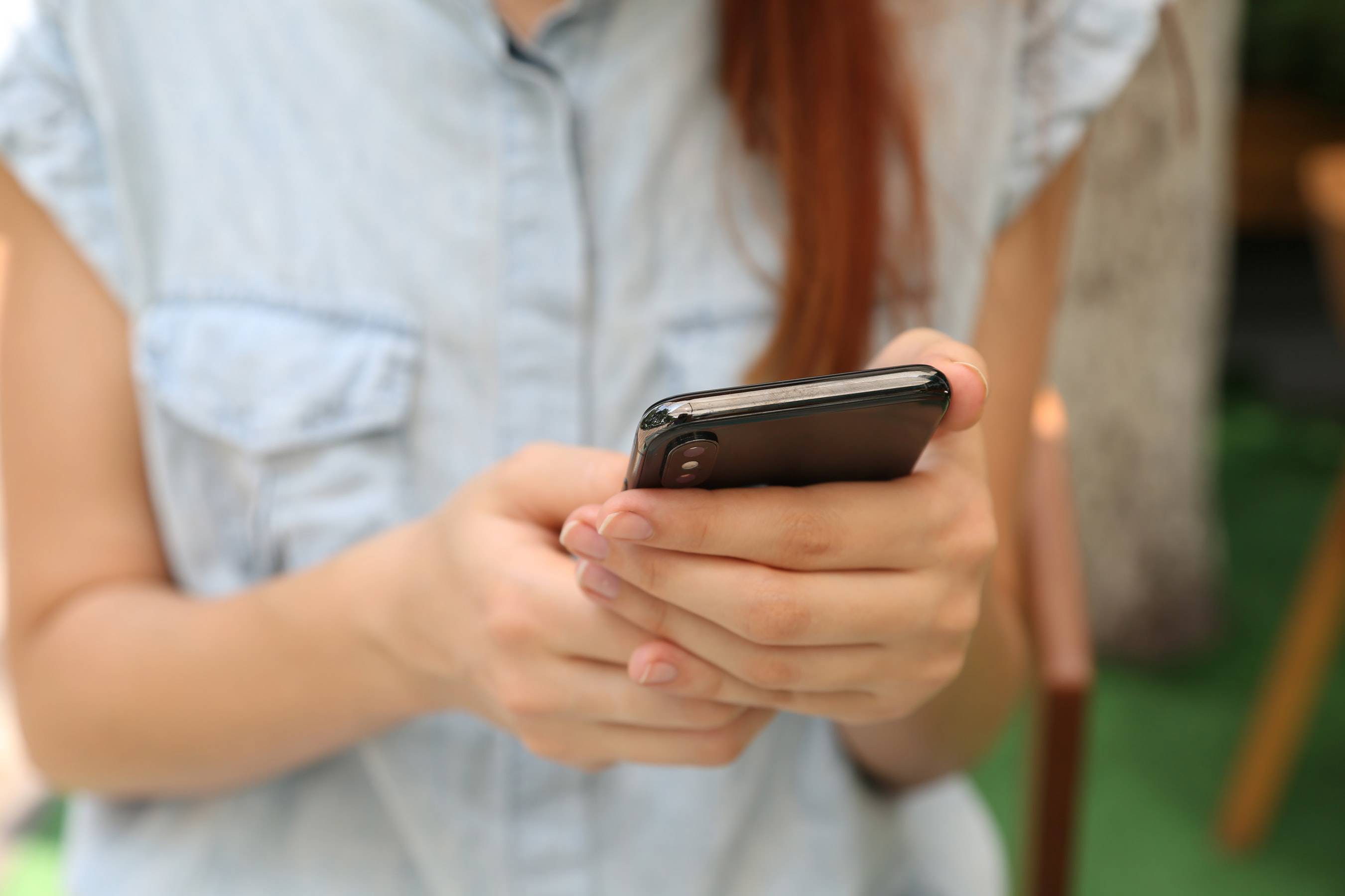 Vrouw met mobiel toestel in haar handen