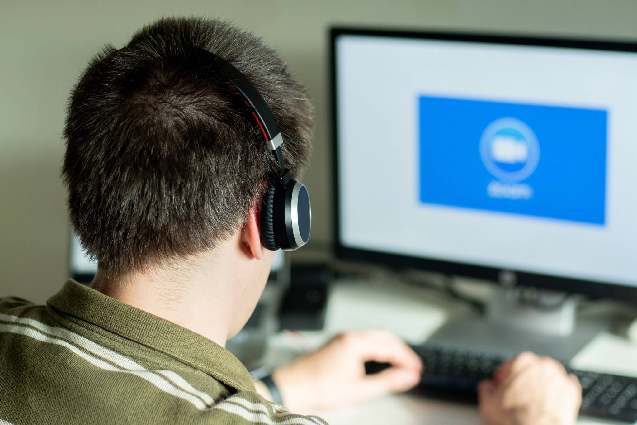 Man With Headphones Looking On The Monitor With Zoom Cloud Meetings Logo Business Cloud Communication T20 Nljy7o