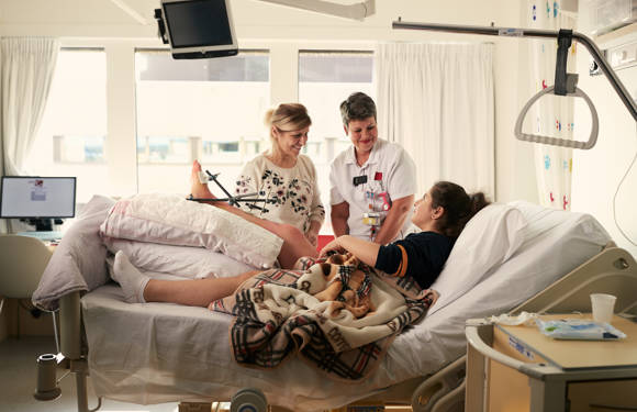 Patiënt met gebroken been in overleg met familie en verpleegkundige